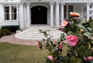 White mansion with flowers on foreground in New Orleans' Garden district